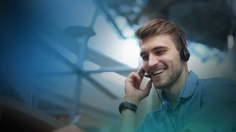 Mann mit Headset telefoniert fröhlich im Büro
